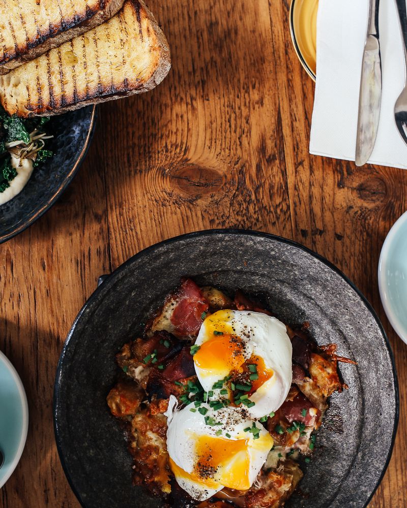 Poached eggs and lattes on a wooden brunch table
