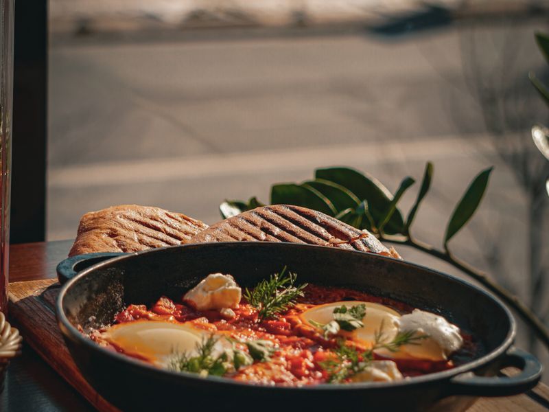 Shakshuka served in a skillet with crusty bread